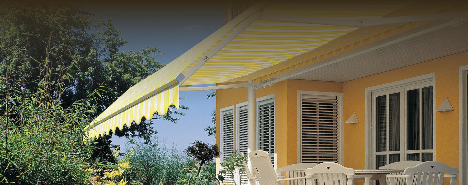 Markise mit gelb-weißen Streifen über Terrasse